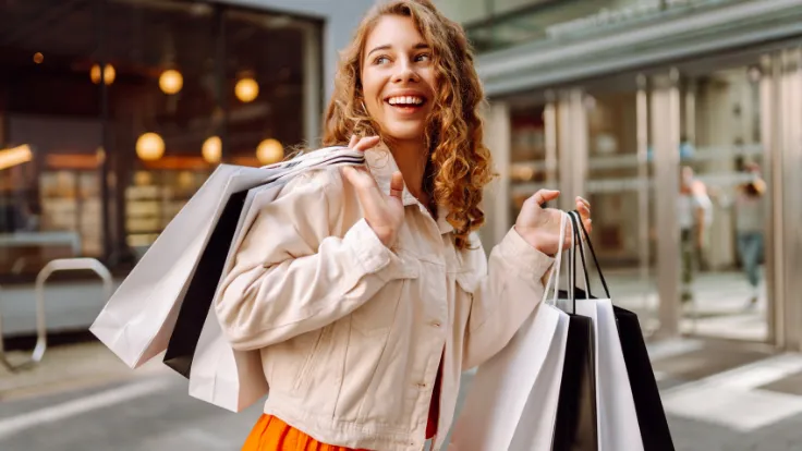 Uśmiechnięta kobieta niosąca zakupy.